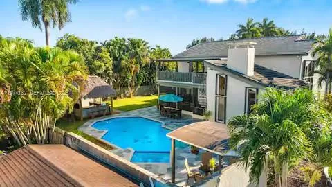Aerial view of backyard oasis with pool and tiki hut!