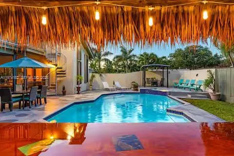 Resort-style pool with thatched cabana lighting!