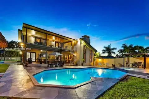 Illuminated modern mansion with geometric pool design!