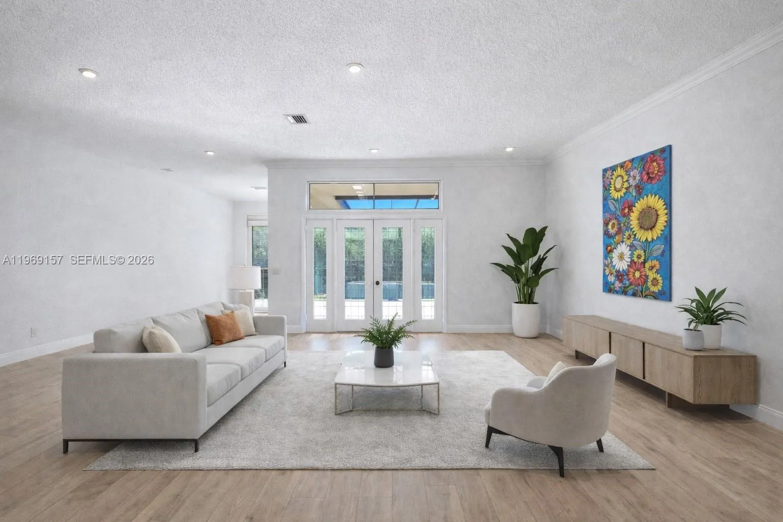 DIGITALLY ENHANCED to show how the living room can look with white walls, neutral flooring and new doors