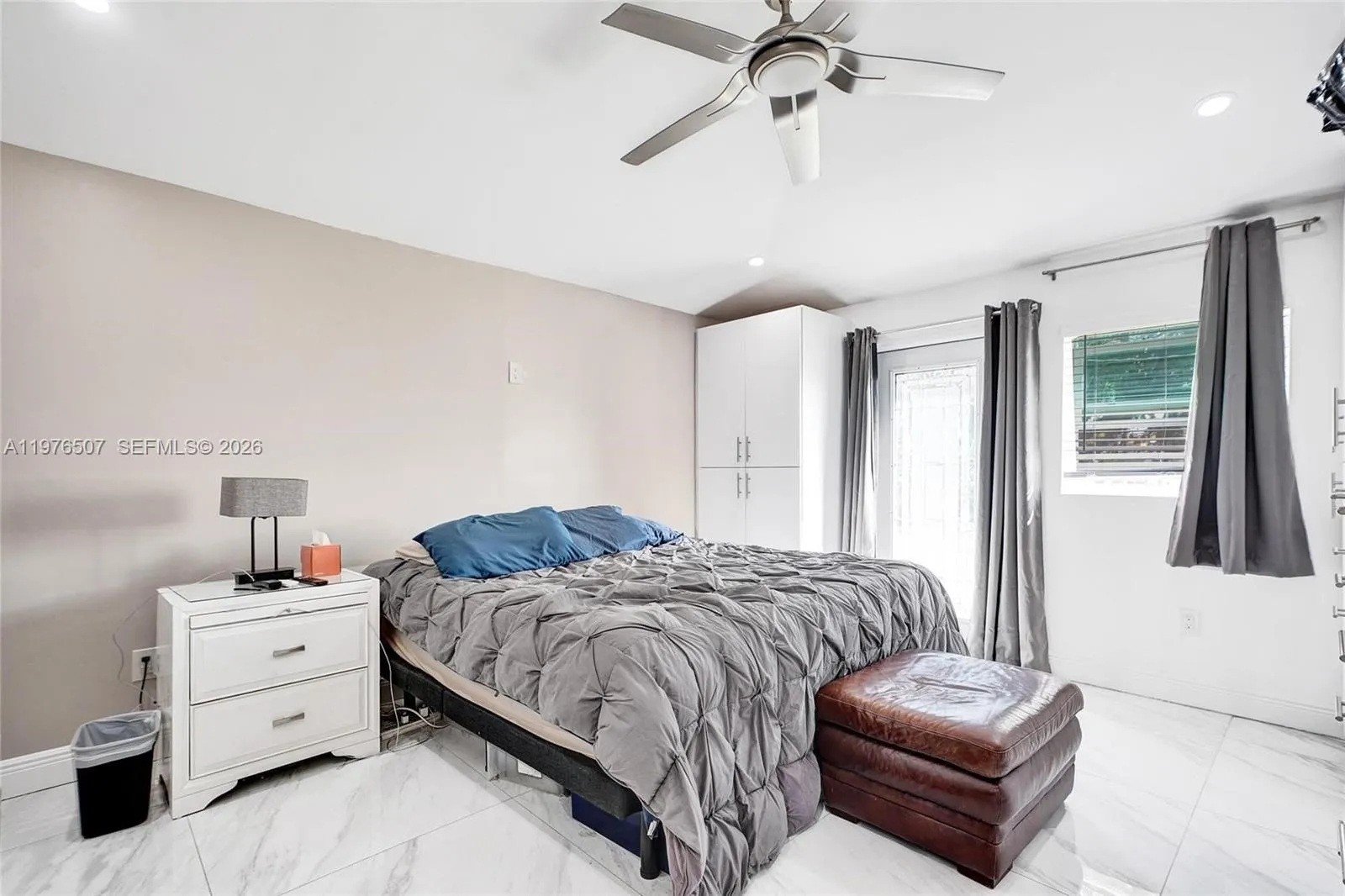PRIMARY MASTER BEDROOM FILLED WITH LIGHT, SITTING ON 33\" X 33\" PORCELAIN TILES AND WITH A SECONDARY DOOR LEADING TO THE BACKYARD!