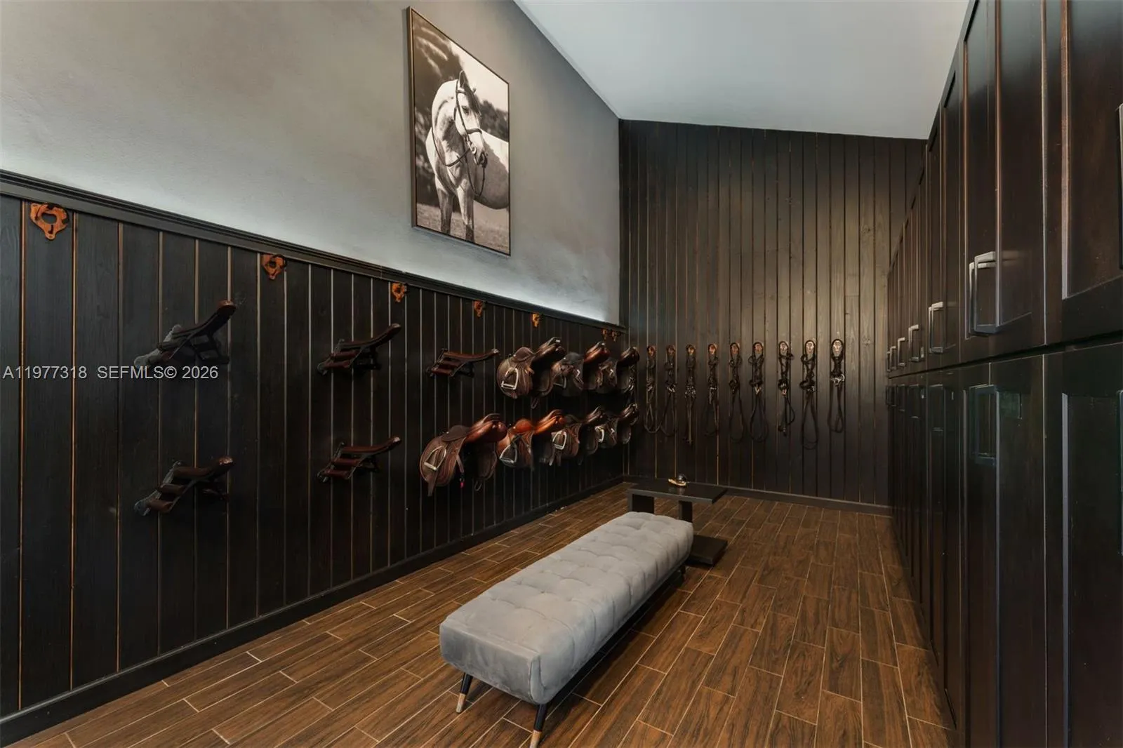 Tack room with high ceilings, sink, and lockers.