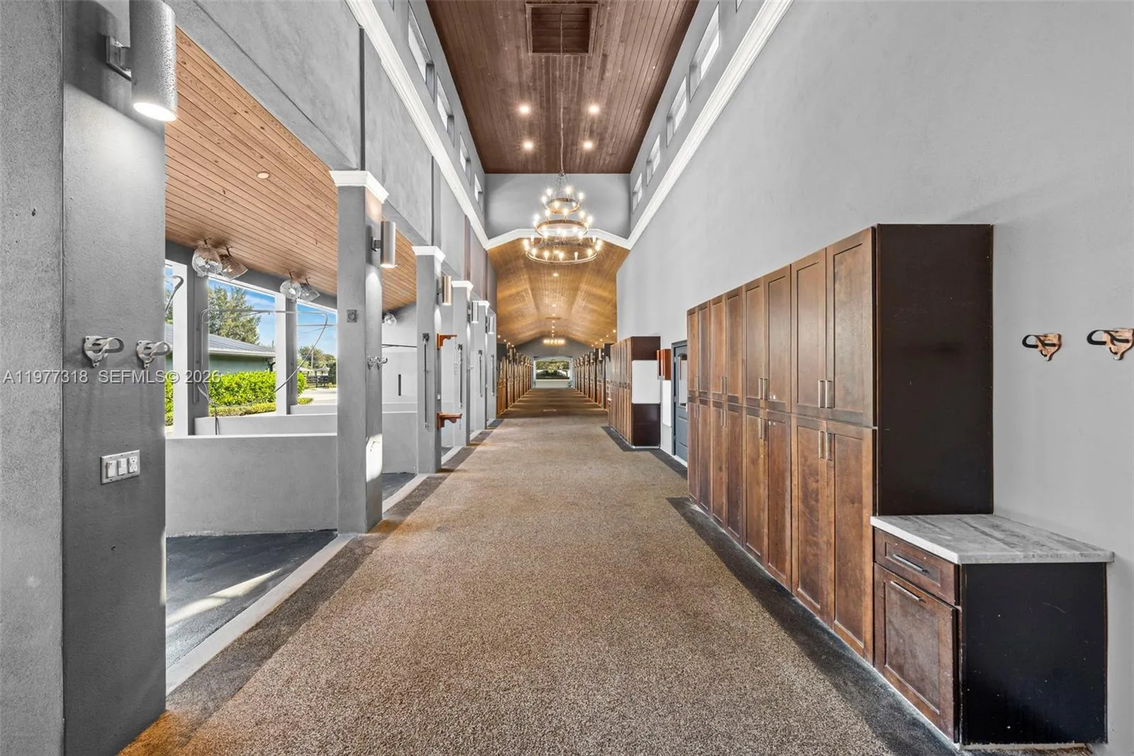 Barn hallway with high tongue & groove ceilings and lockers for supplies.