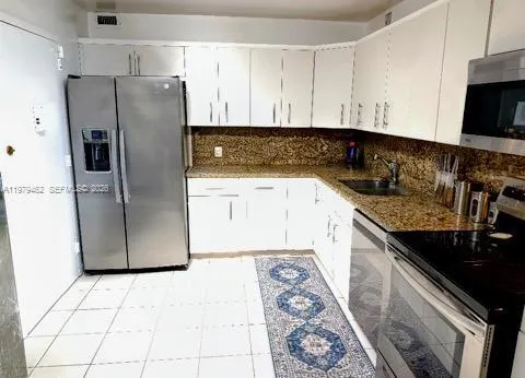 Spacious eat-in kitchen with stainless steel appliances, granite counter pull-out cabinets and private servi9ce entrance delivery door