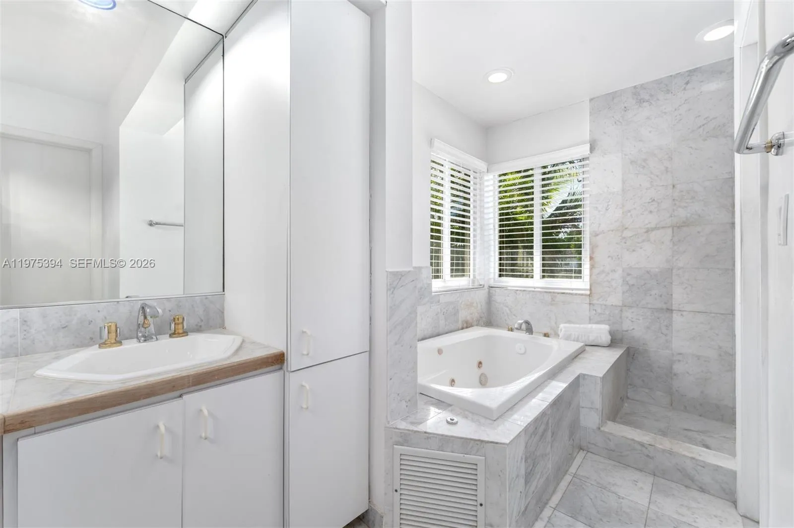 Primary bathroom with dual sinks, jacuzzi tub and shower