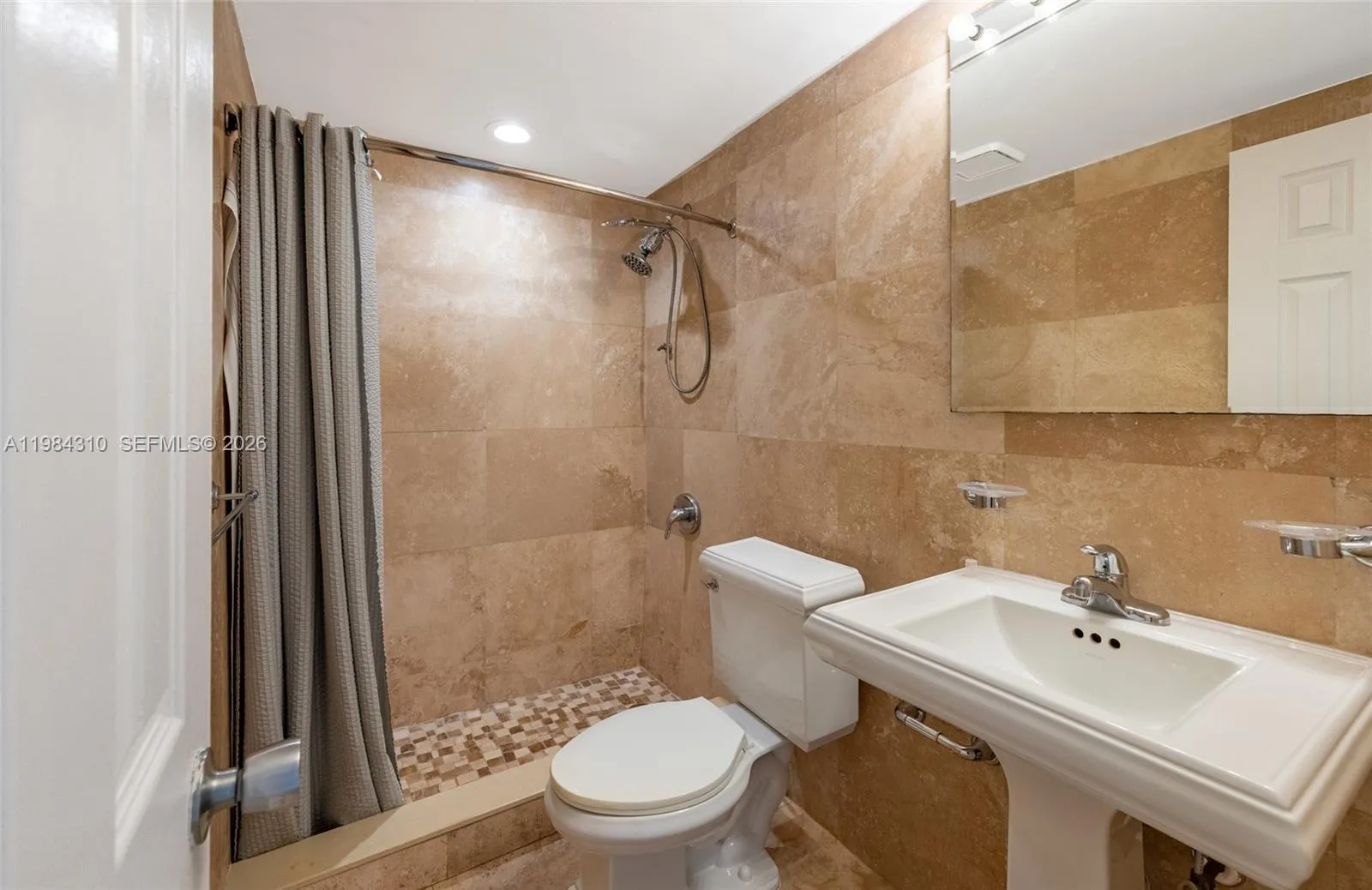 Attractive tile flooring throughout, featuring a beautiful mosaic in the shower area.