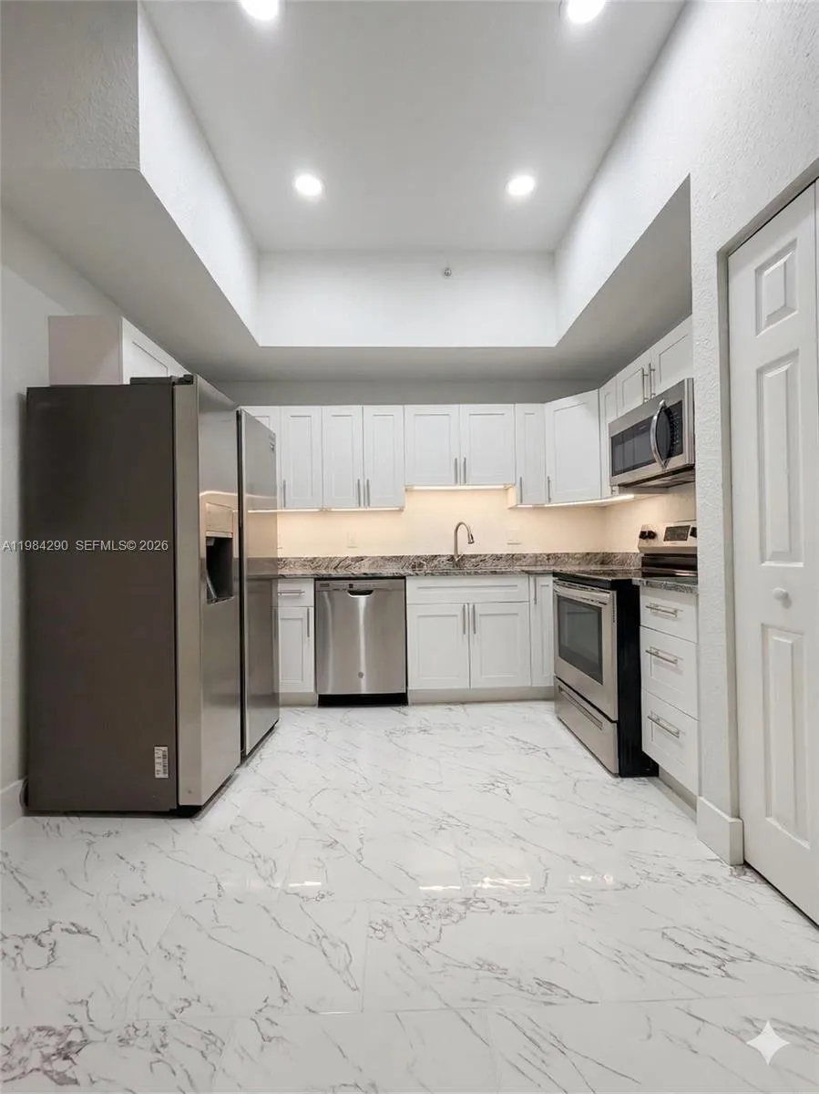 Remodeled kitchen with shaker cabinets and quartz countertops