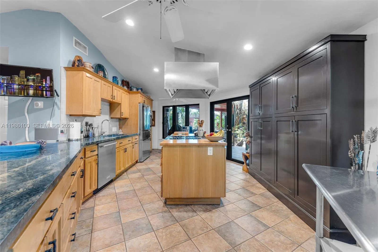CHEFS KITCHEN W/ COOKING ISLAND, GAS GARLAND COMMERCIAL STOVE & OVEN W/ HOOD VENT & BUTCHER BLOCK/GRANITE COUNTERTOPS, CUSTOM CABINETSW/ FRENCH DOORS LEADING TO THE BREEZEWAY TO CASITA.THE 3 CAR CARPORT IS LOCATED IN THIS AREA.