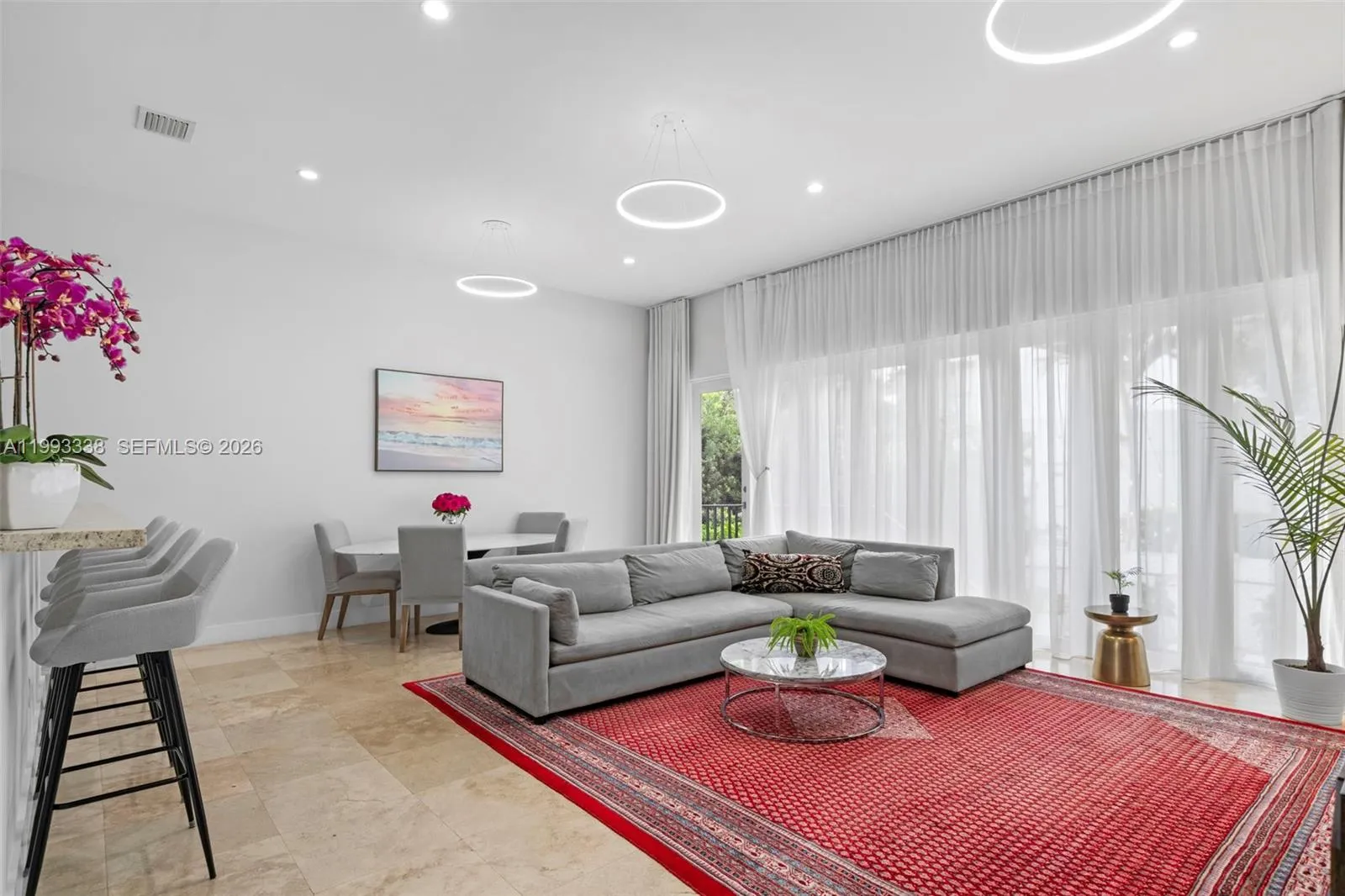 Bright open living area/w 11-ft ceilings & floor-to-ceiling windows & entrance to Private Back Yard.