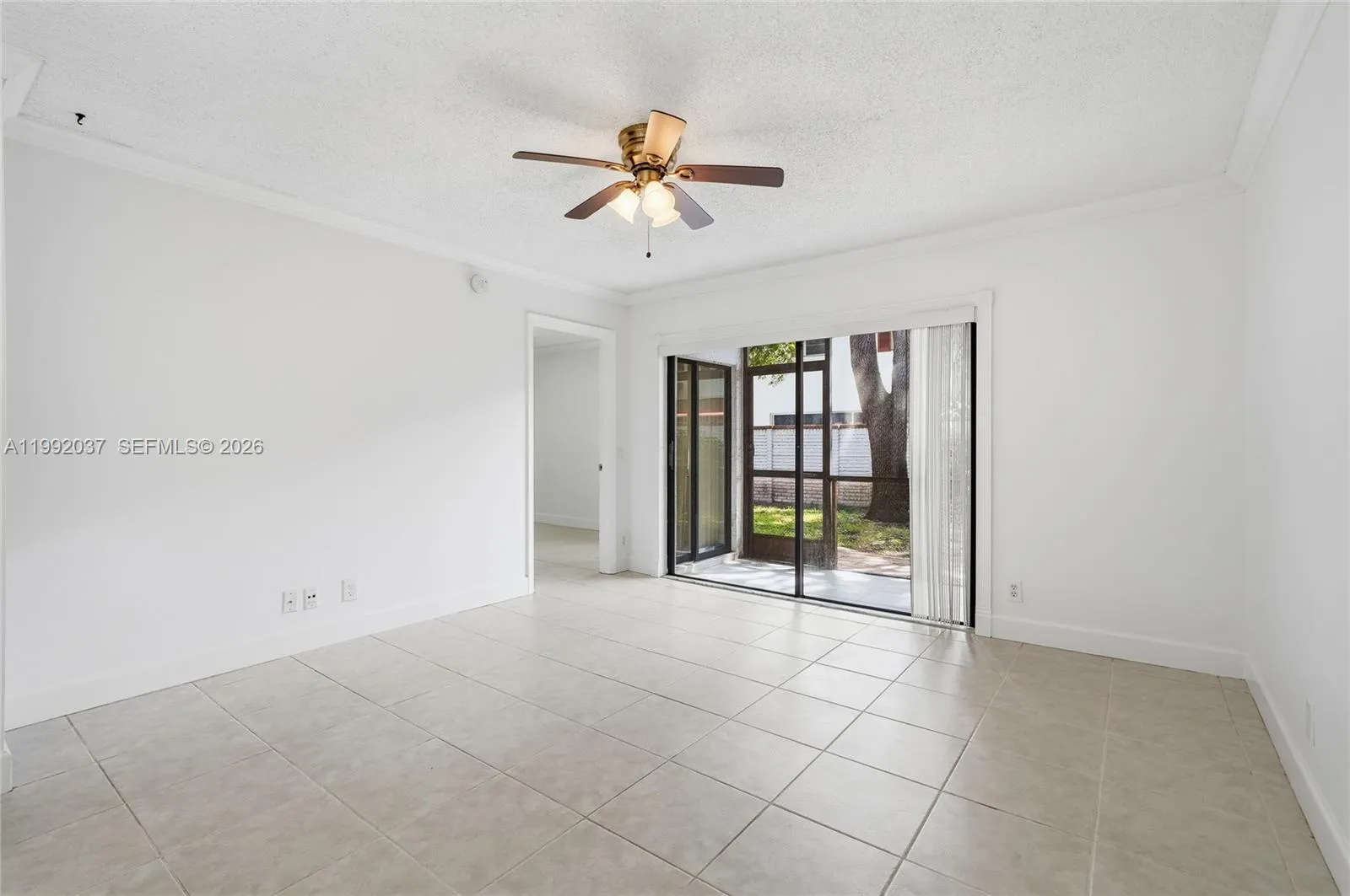Spacious living area with open layout and ceiling fan