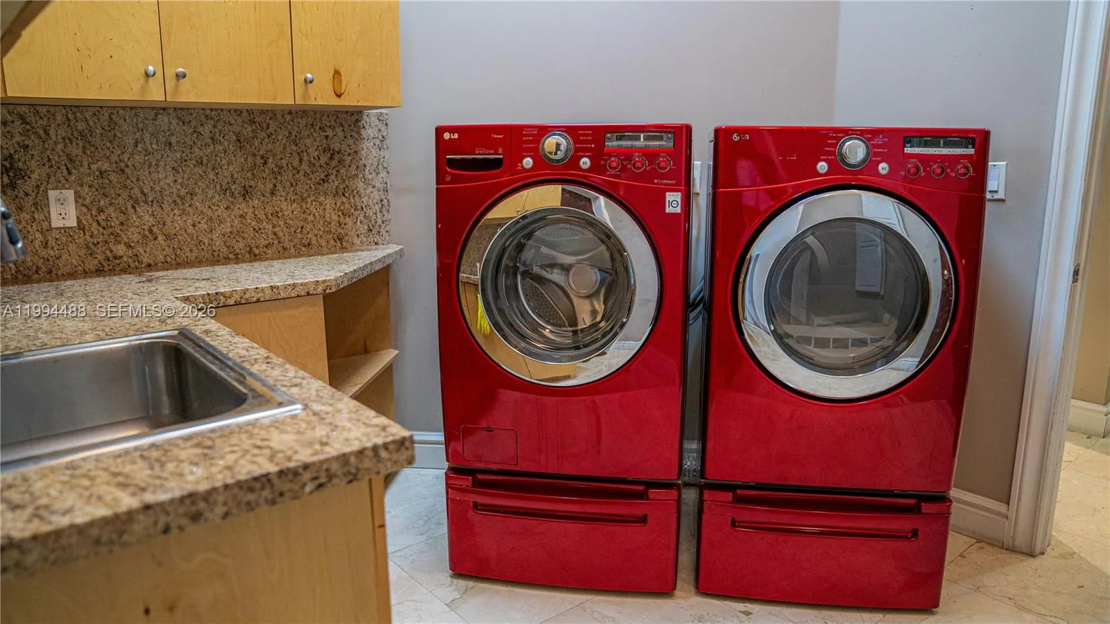 Ample space laundry with plenty of cabinets and sink