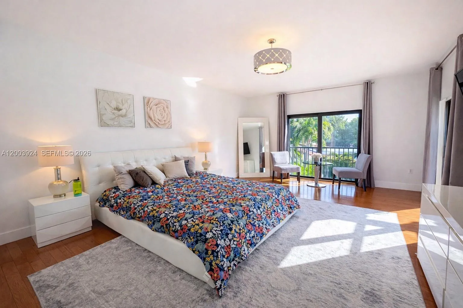 large primary bedroom suite with sitting area, large ensuite bathroom, floor to ceiling window, glass door to second floor terrace, walk-in closet and additional built-in closets.