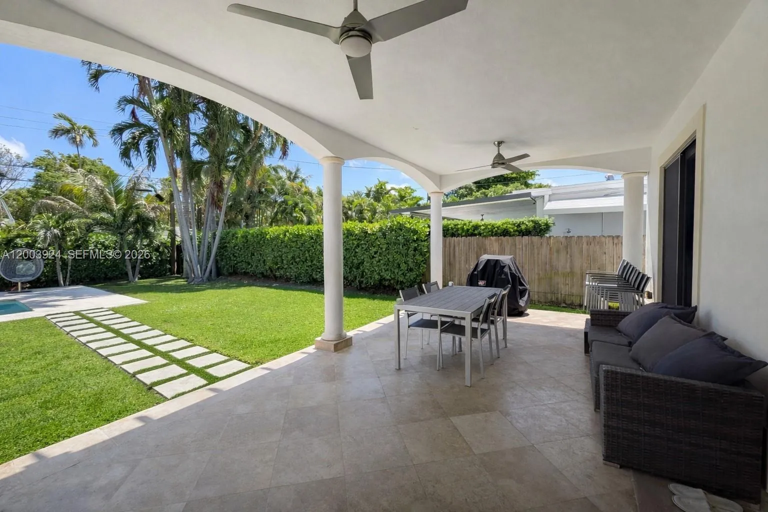 first floor terrace to back yard and pool connects to living room and dining area via multiple floor-to-ceiling glass doors.   ceiling fans and lights are perfect for hosting and entertaining.
