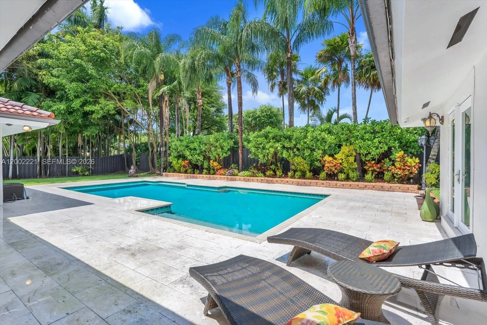 Extra large pool with manicured landscaping on one end of the pool deck