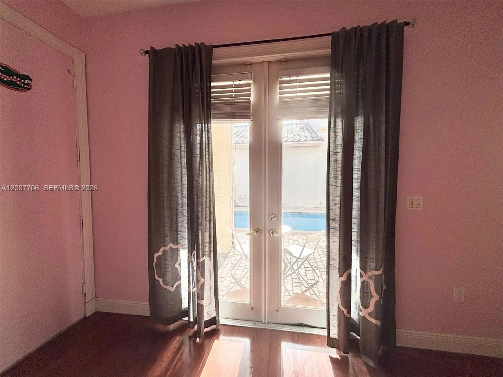 Bedroom has french doors overlooking the pool