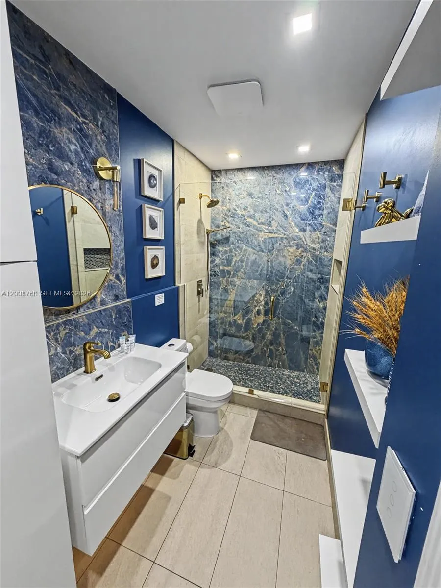 Beautifully renovated bathroom with designer blue-tile accent walls