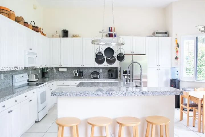 Huge kitchen with high ceilings, center island, snack counter and breakfast table.