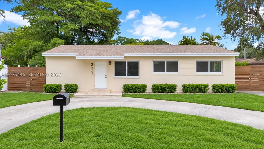 Classic street-facing view of 321 — a well-maintained ranch home with fresh exterior, updated windows, modern wood privacy fencing on both sides, and a generous green front yard. AI-edited photograph for marketing purposes.