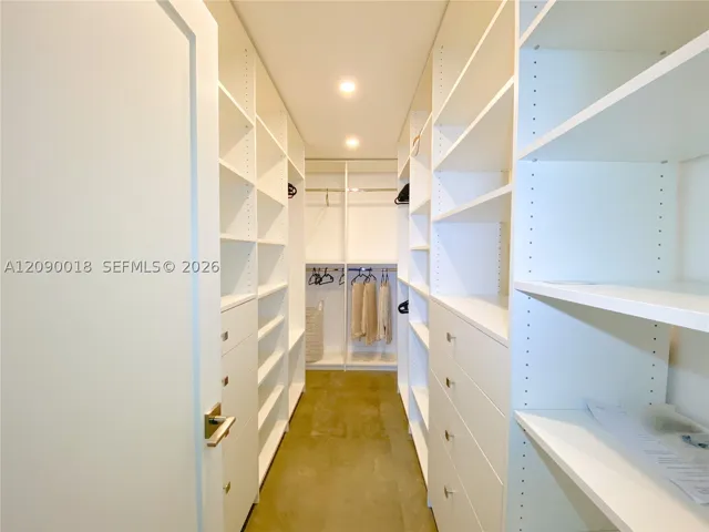 Generous walk-in closet with custom shelving and drawers.