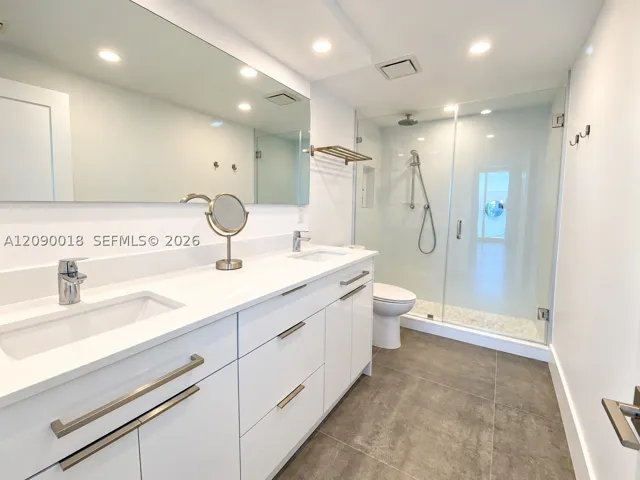 Primary bathroom with dual sink vanity and modern finishes.
