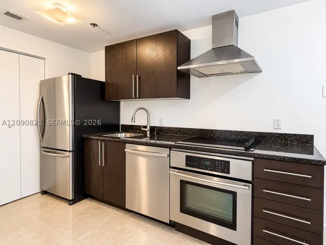 Modern kitchen featuring dark cabinetry, stainless steel appliances, and built-in microwave.
