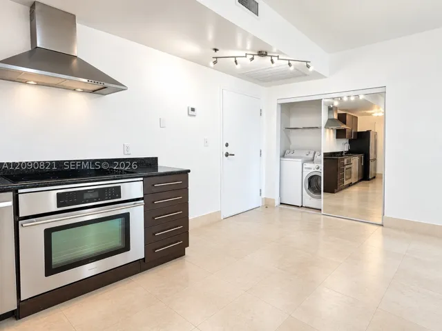 Open kitchen layout with breakfast bar counter and ample storage space.