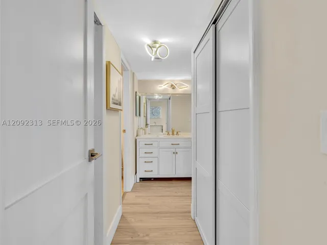 Hallway leading to the primary suite with custom built-in closets and private bathroom
