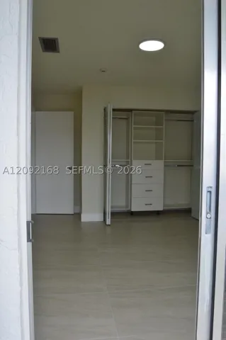 VIEW OF THE 2ND BEDROOM WITH BALCONY'S BRAND NEW CLOSETS
