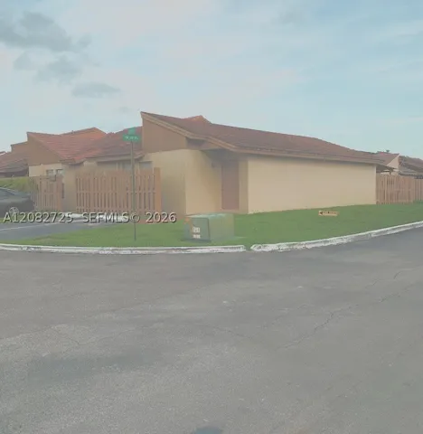 Side-front, exterior photograph illustrates the side-by-side configuration of the two-car driveway parking directly in front of the property.