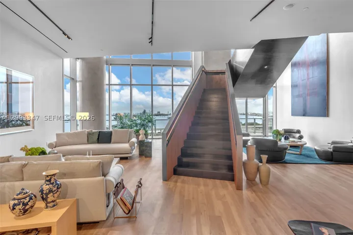Two story social lounge with sculptural staircase and bay views