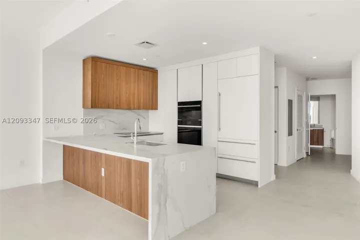 Italkraft kitchen with white oak cabinetry and porcelain waterfall island