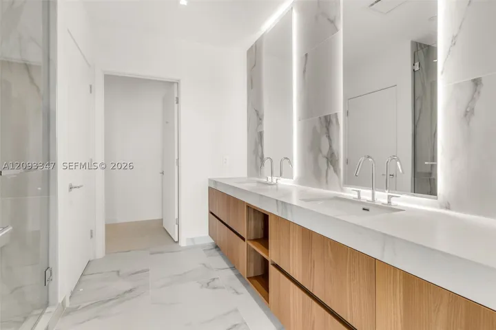 Primary bath with double vanity, backlit mirrors and Statuario Select porcelain