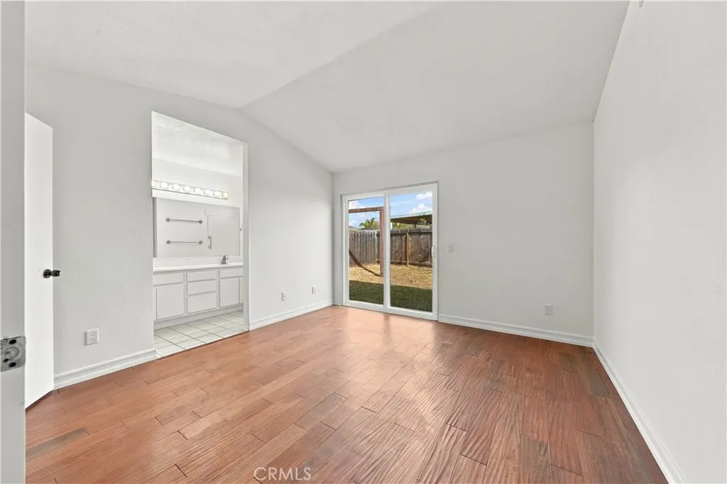 Primary bedroom w dual pane glass sliding doors to back yard area.