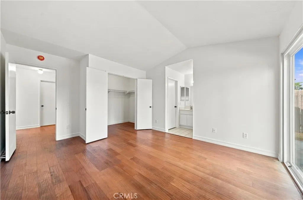 Alternate view of primary bedroom w walk in closet thru double door on the left