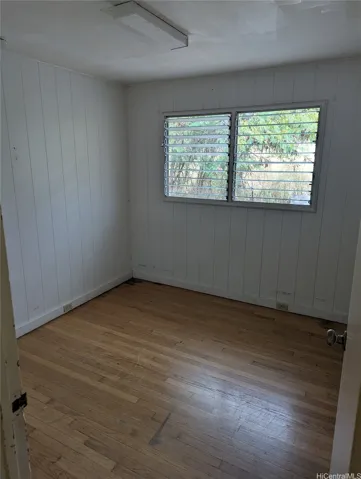 bedroom in smaller home, note hardwood floors throughout