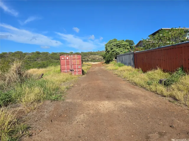 Between the red and blue containers is where the land separates from agriculture and residential.

The picture was taken from the residential side.