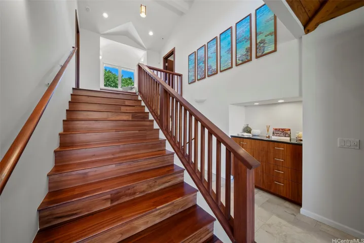 Wide staircase of Tigerwood flooring lead to the second level.
