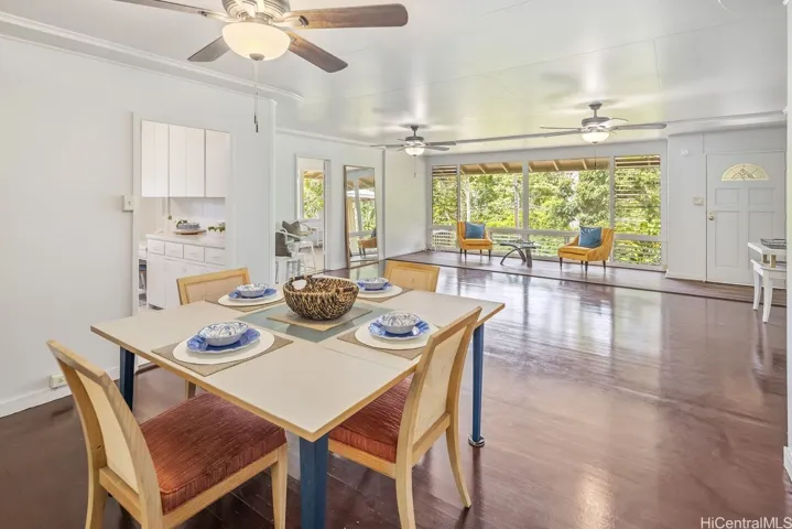 Dining room opens to living area with green rainforest view