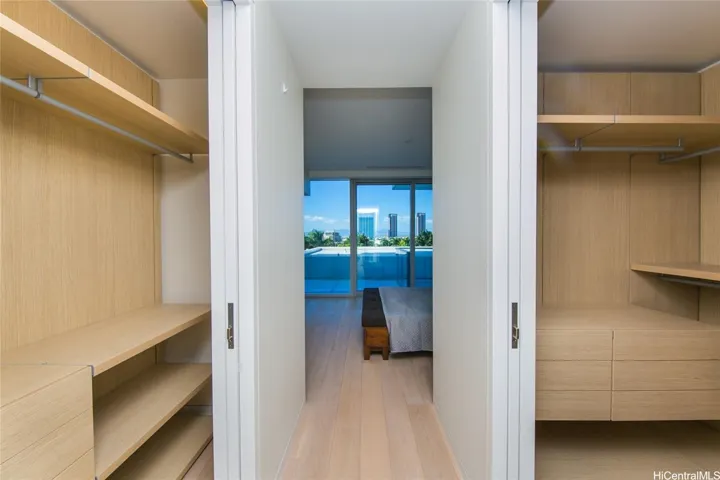 Walkway from the bath to the main bedroom with the 2 closets aross from each other.