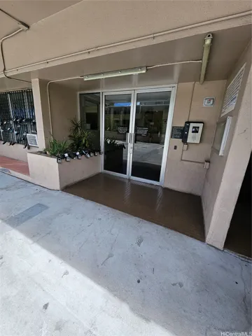 Lockbox on railing by plants on the left side - yellow Help-U-Sell keychain attached.