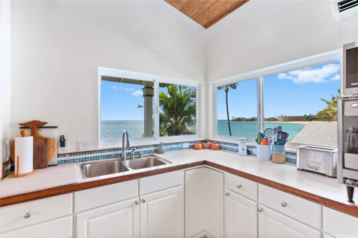 Enjoy breathtaking beachfront views of Makaha Beach right from your kitchen window. This rare oceanfront home offers stunning sunsets, private deck, and peaceful island living just steps from the shore.
