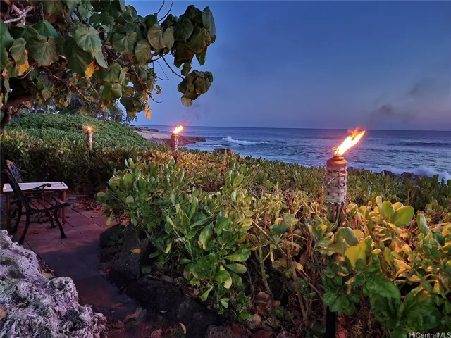 Enjoy cool ocean breezes in the tiki torch-lit beachfront backyard. Relax evenings surrounded by gentle waves, warm island ambiance, and stunning sunset views in your private Makaha paradise.