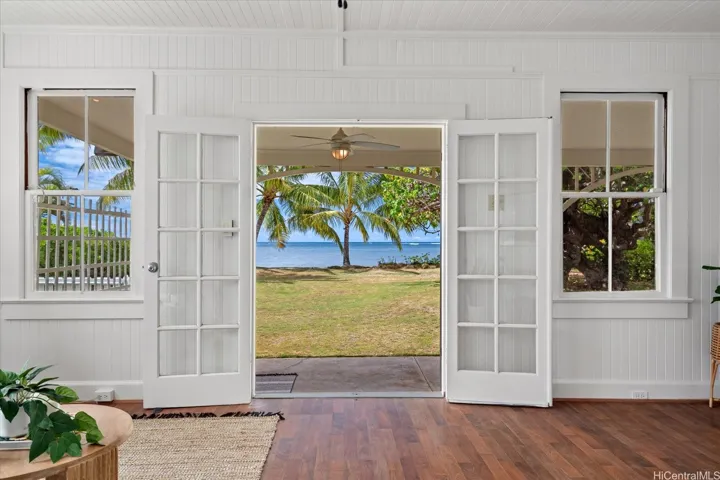 Double doors from the living room lead out to the covered lanai and the beach