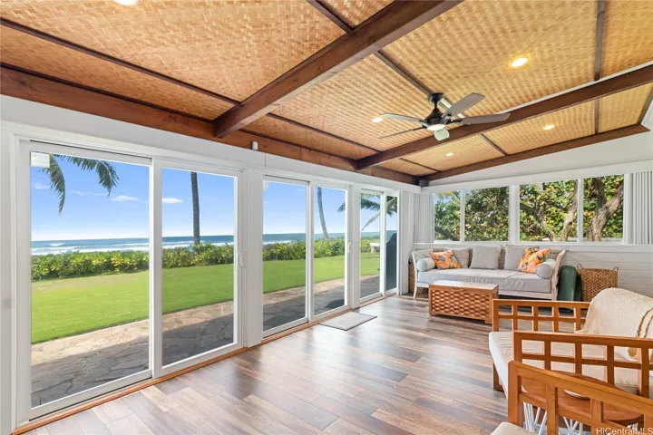 The ocean-view living room is flooded with natural sunlight, creating a warm and inviting space to relax, entertain, or simply take in the beauty of the Pacific. Large windows frame sweeping views, making the sea feel like an extension of your living space. North Shore Haleiwa Hawaii.