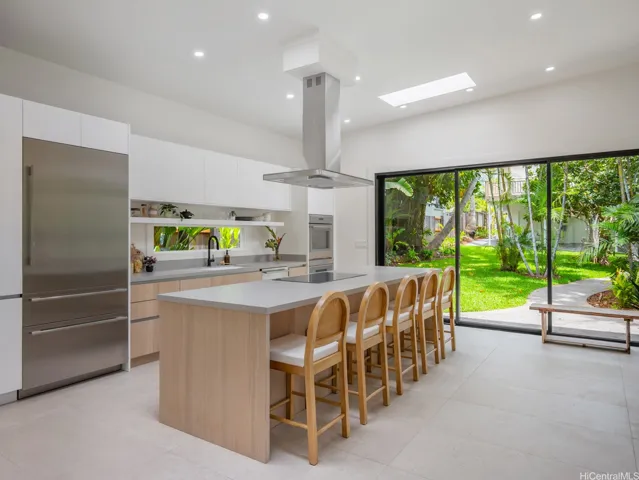 Step into your dream kitchen—a true work of art—featuring a spacious island with seating, sleek countertops, custom cabinetry, an architectural range hood, and premium Thermador appliances. A separate laundry room sits just behind the kitchen for added convenience.
