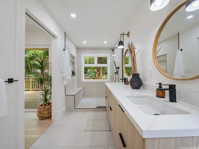 This luxurious ensuite bath invites nature in, with eucalyptus trees just outside the shower window offering privacy and a serene, spa-like backdrop. Floating under-lit dual vanities, high-end finishes, and thoughtful design elevate the experience of everyday living.