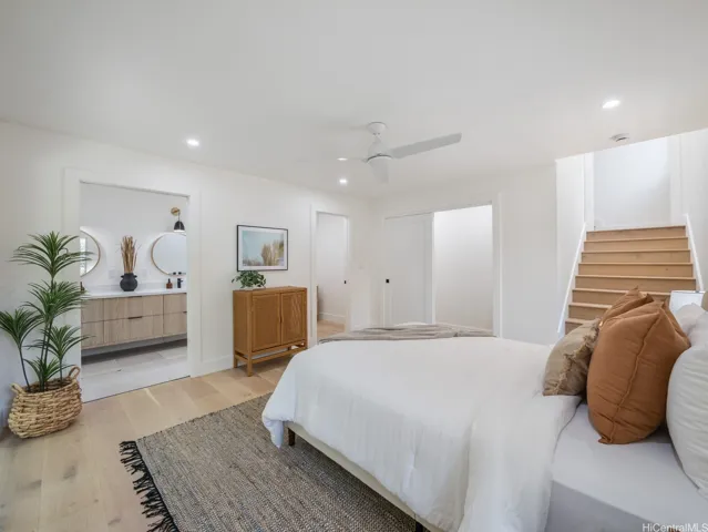 This second primary suite is downstairs through a wide, bright and sunlit staircase. This bedroom offers both a walk-in and a customizable reach-in closet and a walk-in closet, a spa-like ensuite bath, and direct access to a private lanai—creating a perfect blend of comfort, luxury, and functionality.
