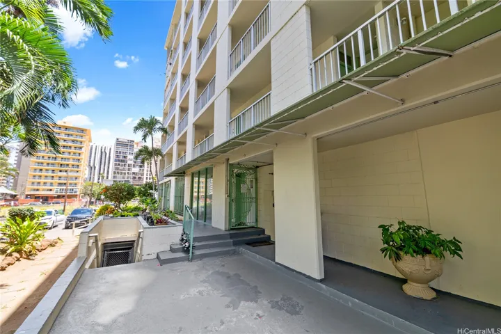 The main building entry is accessed from Kapili Street with secured doors and planter beds.