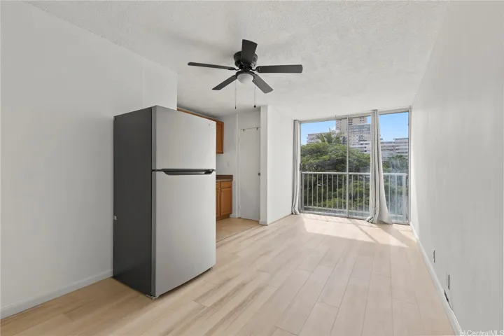 Bright studio space with new flooring and a large window overlooking the surrounding greenery.