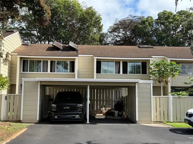View of the apartment with covered parking on the right side.